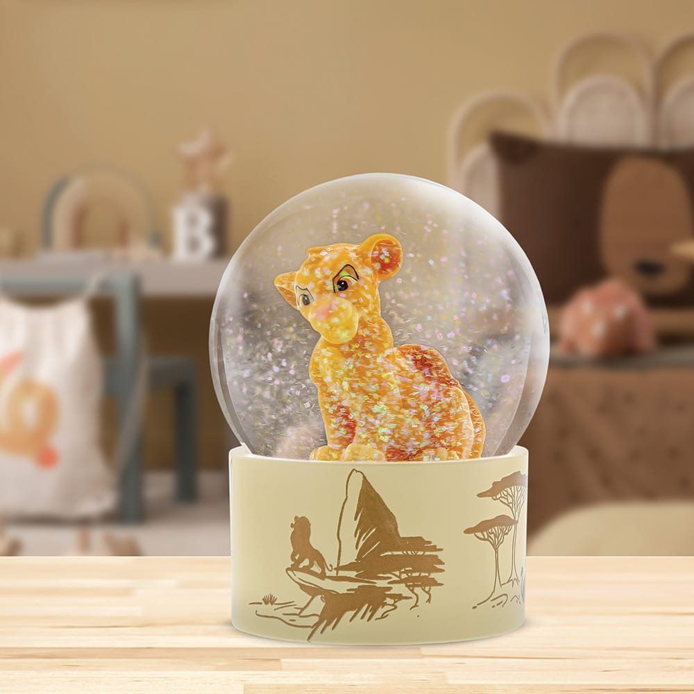 Sneeuwbol van de Leeuwenkoning met Simba erin, op een tafel. Goud en wit van kleur.