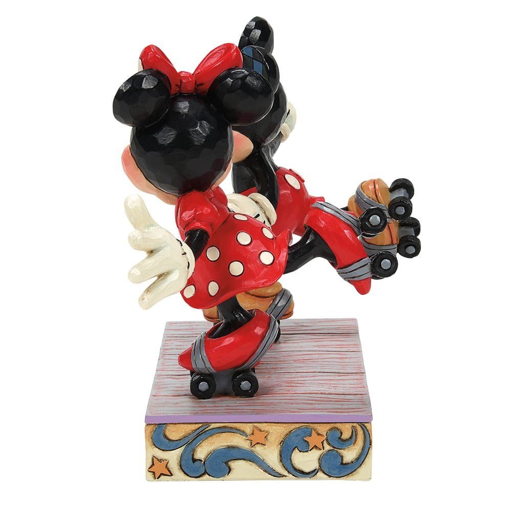 Mickey en Minnie Mouse-figuurtjes, hand in hand, in rode en zwarte outfits, staan op een sokkel met hartjes.