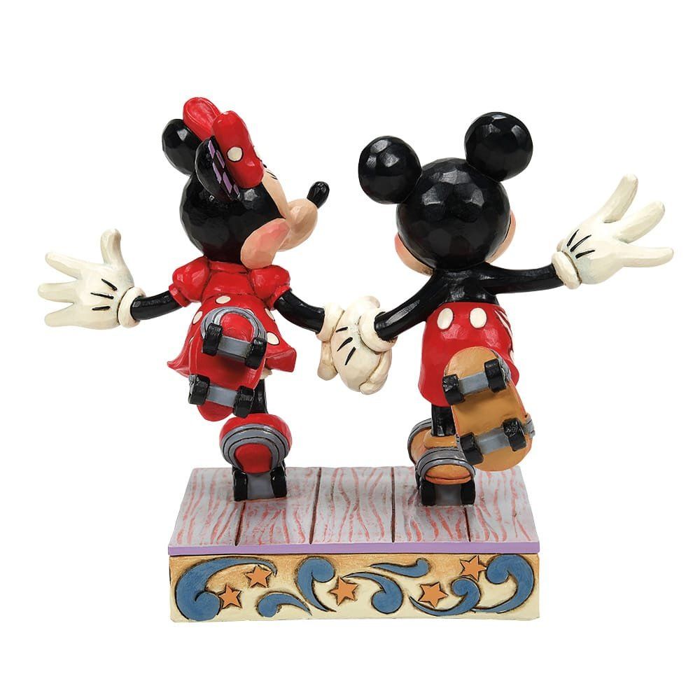 Mickey en Minnie Mouse beeldjes, schaatsend en hand in hand, op een decoratieve sokkel.