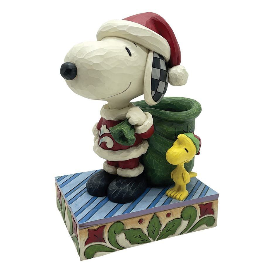 Snoopy verkleed als Kerstman met Woodstock, groene zak, rood pak en blauw gestreepte basis.