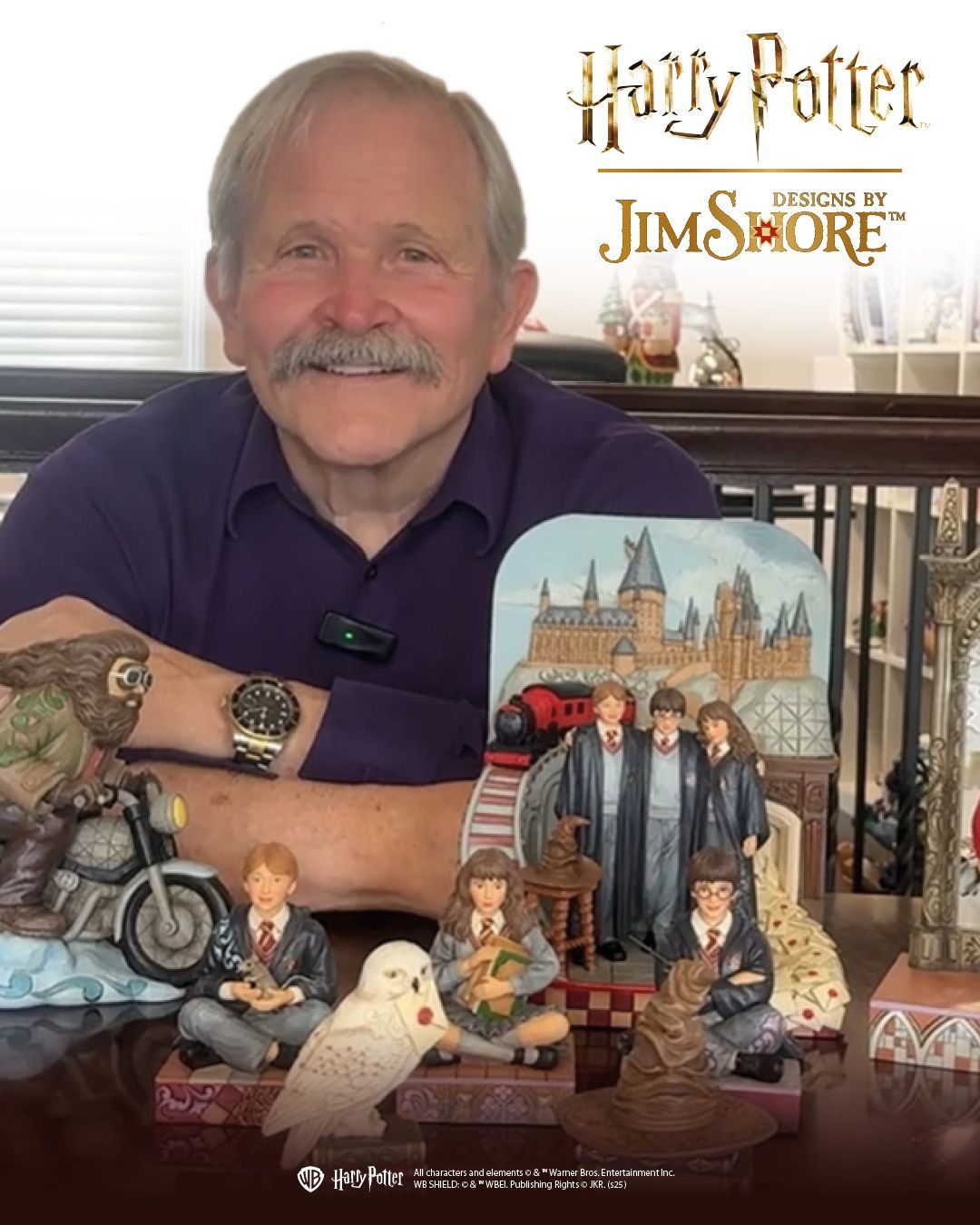 Jim Shore met Harry Potter-beeldjes. Lachend, in het paars gekleed, binnen gefotografeerd.