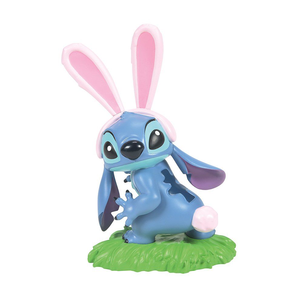 Een figuurtje van Stitch met konijnenoortjes, zittend op groen gras.