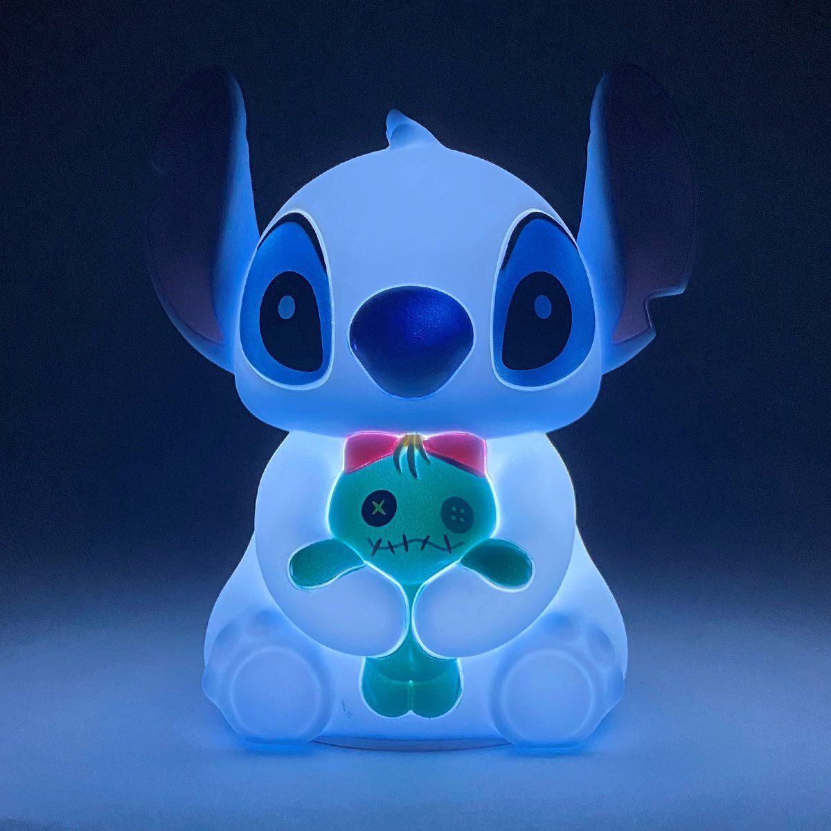 Een lichtgevend blauw Stitch-nachtlampje met een groene scrump erin.