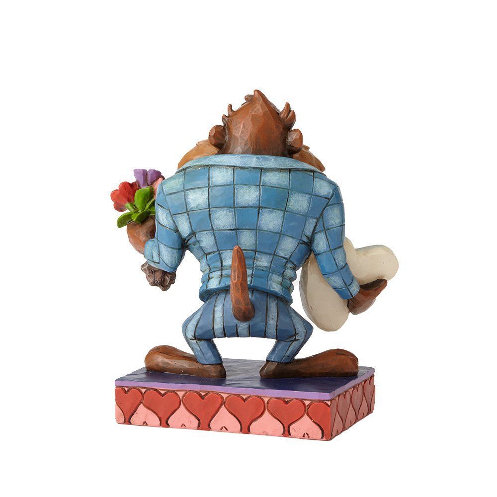 Een beeldje van de Tasmaanse duivel, met een biefstuk en bloemen in zijn handen, in pak en lachend op een platform met een hartvormig thema.