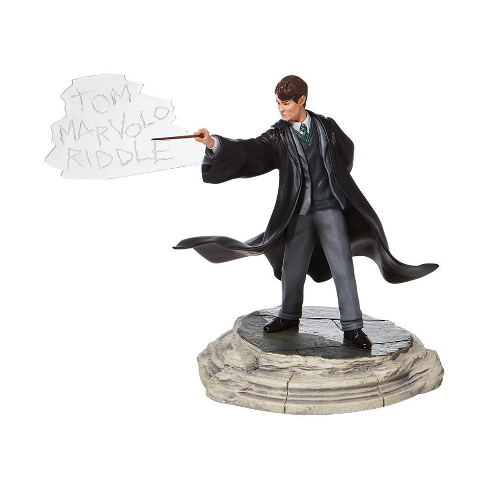 Standbeeld van Tom Marvolo Riddle, in Zweinstein-gewaad, gebarend met toverstaf. Een tekstballon met zijn naam zweeft ernaast.