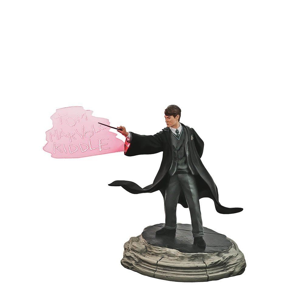 Standbeeld van Tom Marvolo Riddle, in Zweinstein-gewaad, gebarend met toverstaf. Een tekstballon met zijn naam zweeft ernaast.