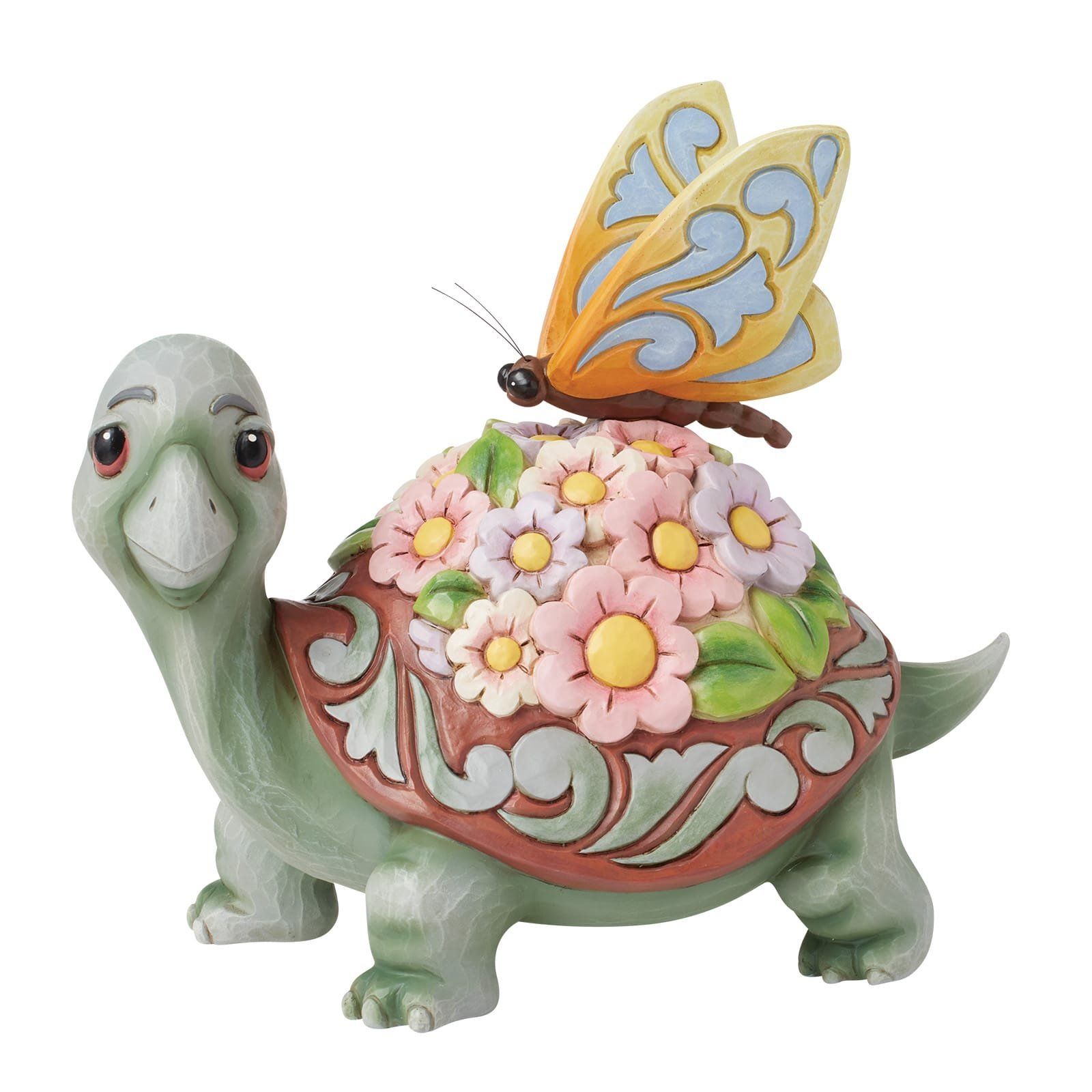 Groene schildpadfiguur met een bloemenmotief op het schild en een vlinder.