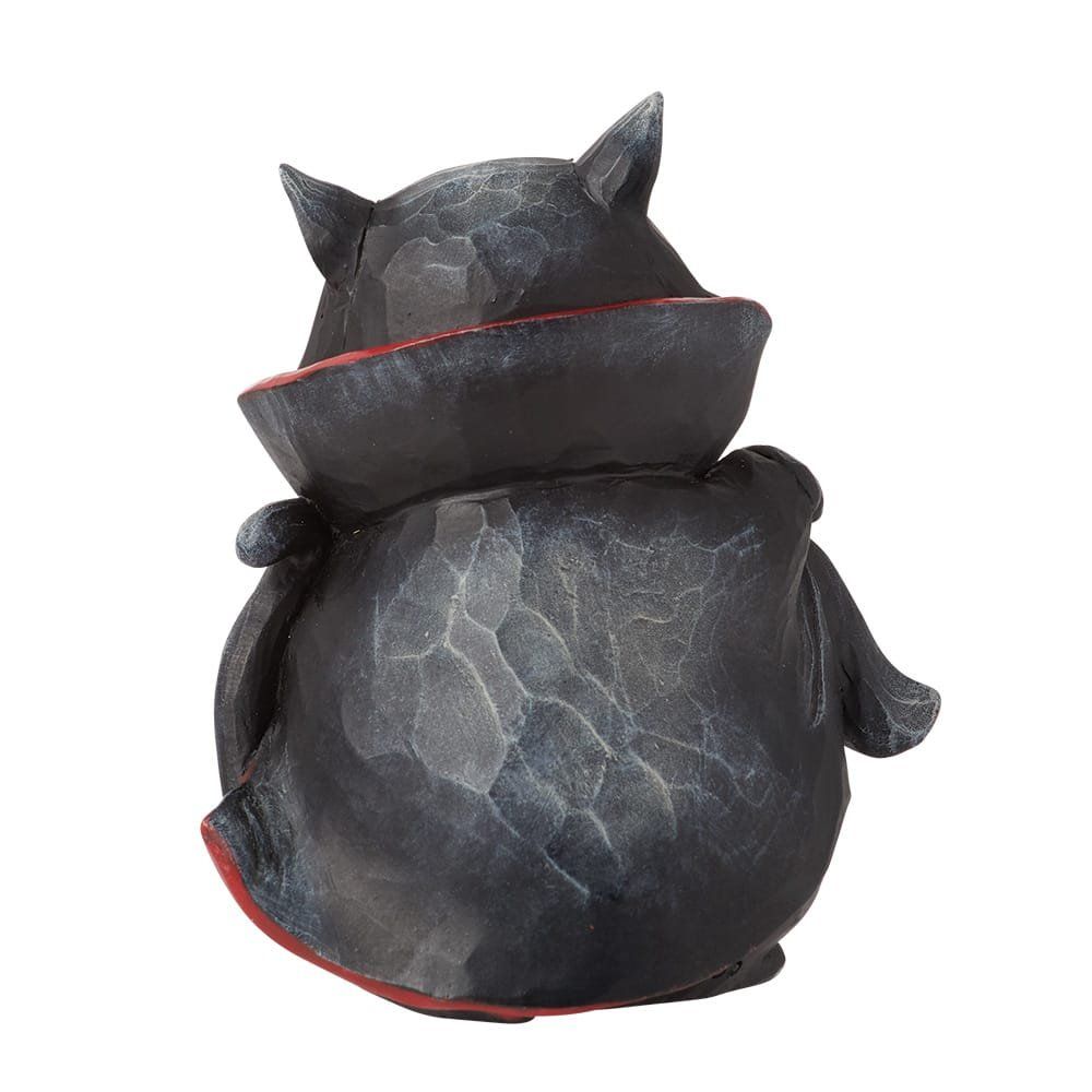 Een beeldje van een zwarte kat in een vampierkostuum met rode cape en vlinderdas.