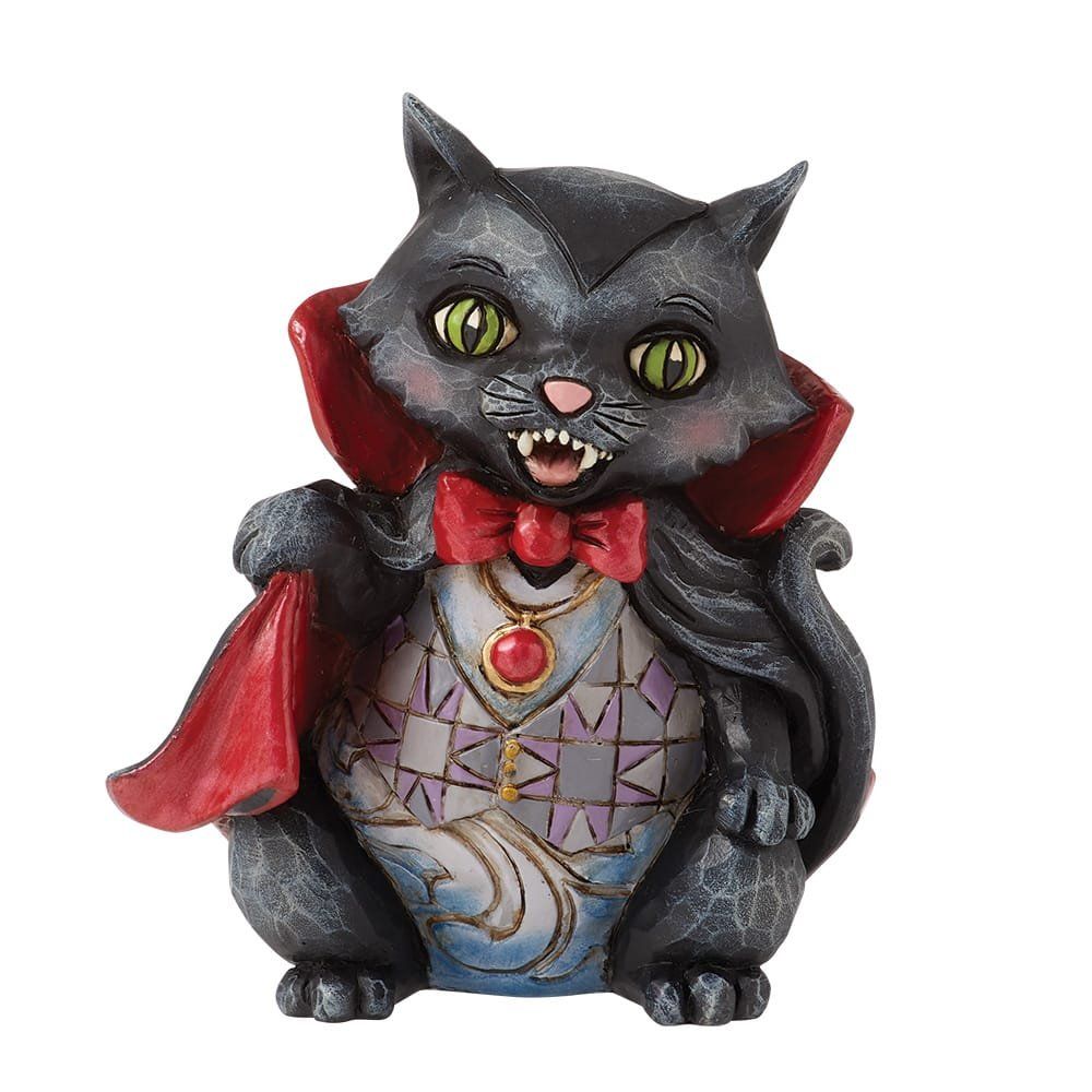 Een beeldje van een zwarte kat in een vampierkostuum met rode cape en vlinderdas.