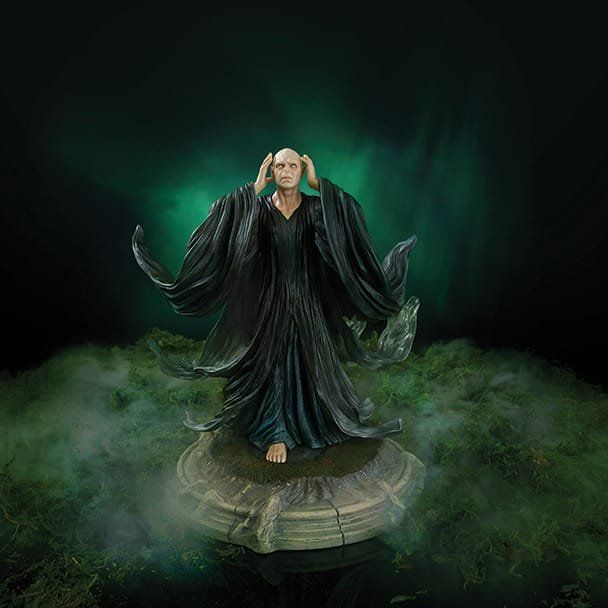 Standbeeld van Heer Voldemort, kaal hoofd, donkere gewaden, opgeheven armen, groene achtergrond met mist.