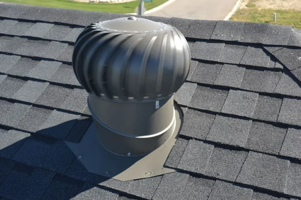 A roof with shingles and a turbine on top of it