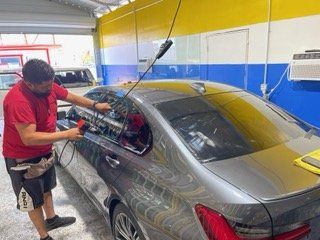 Man Cleaning a Small Car — Sacramento, CA — Low Cost Auto Glass & Window Tinting