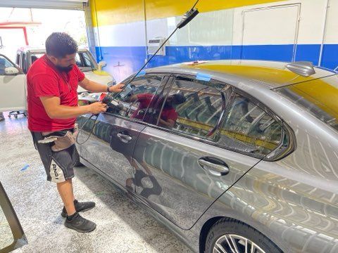 Man Installing on a Small Car — Sacramento, CA — Low Cost Auto Glass & Window Tinting