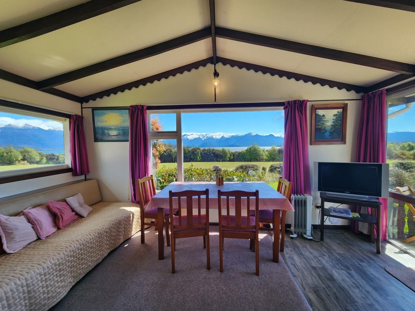Interior view of a dining area with a table set in front of a window overlooking mountains.