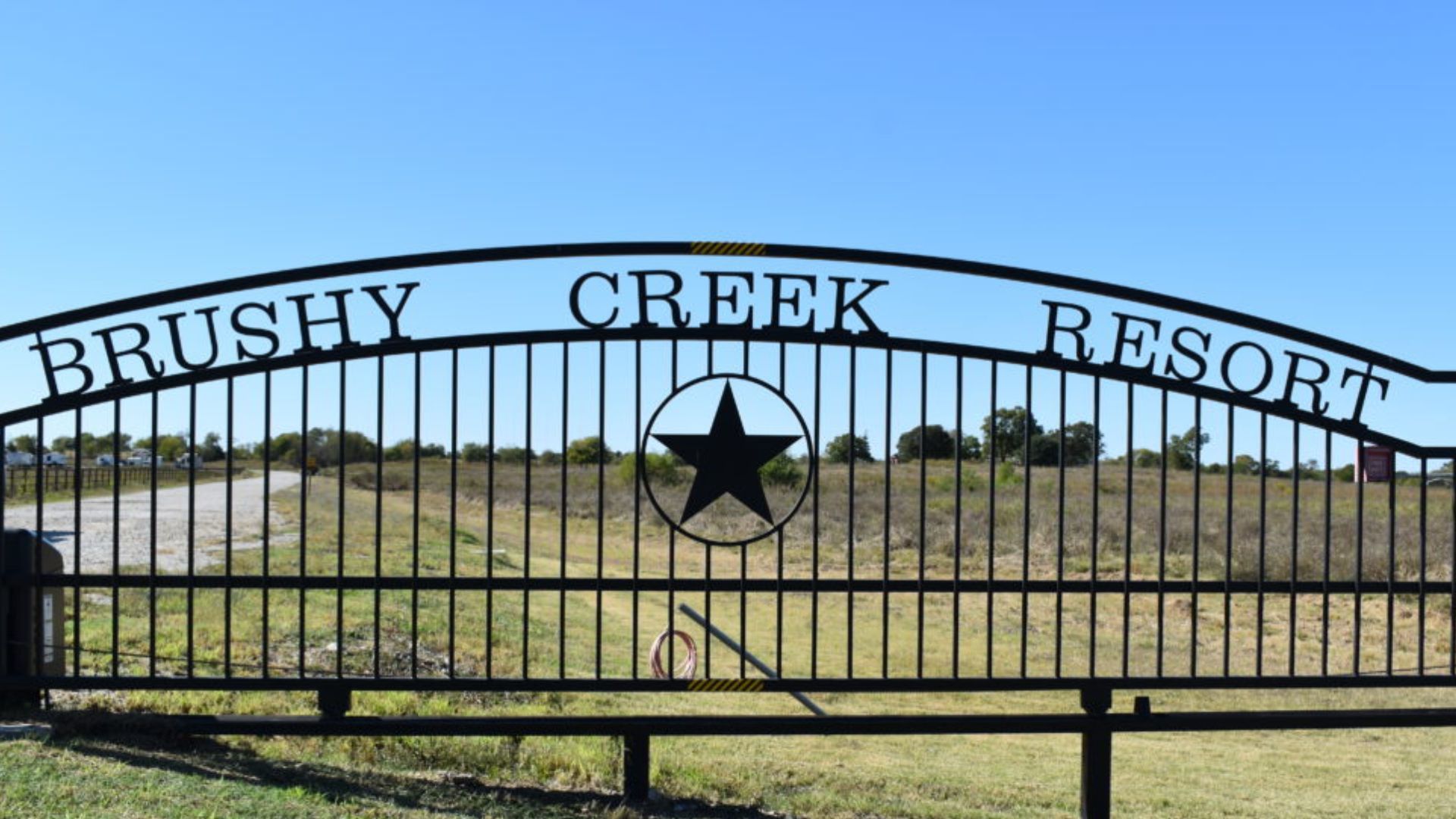 A wrought iron gate with the words brushy creek resort written on it