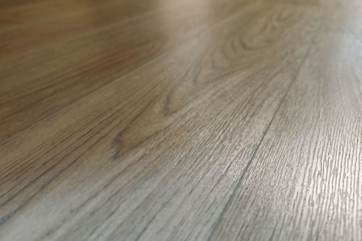 Close-up of light brown wooden floorboards, showing wood grain and sheen. Close-up of light brown wooden floorboards, showing wood grain and sheen.