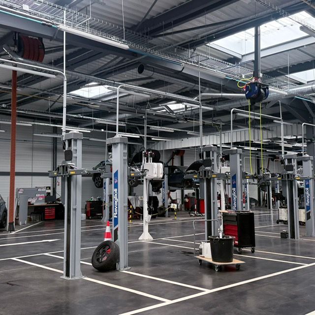 Salle de sport industrielle intérieure avec structures d'exercice suspendues, cordes et équipements sur un sol en béton marqué