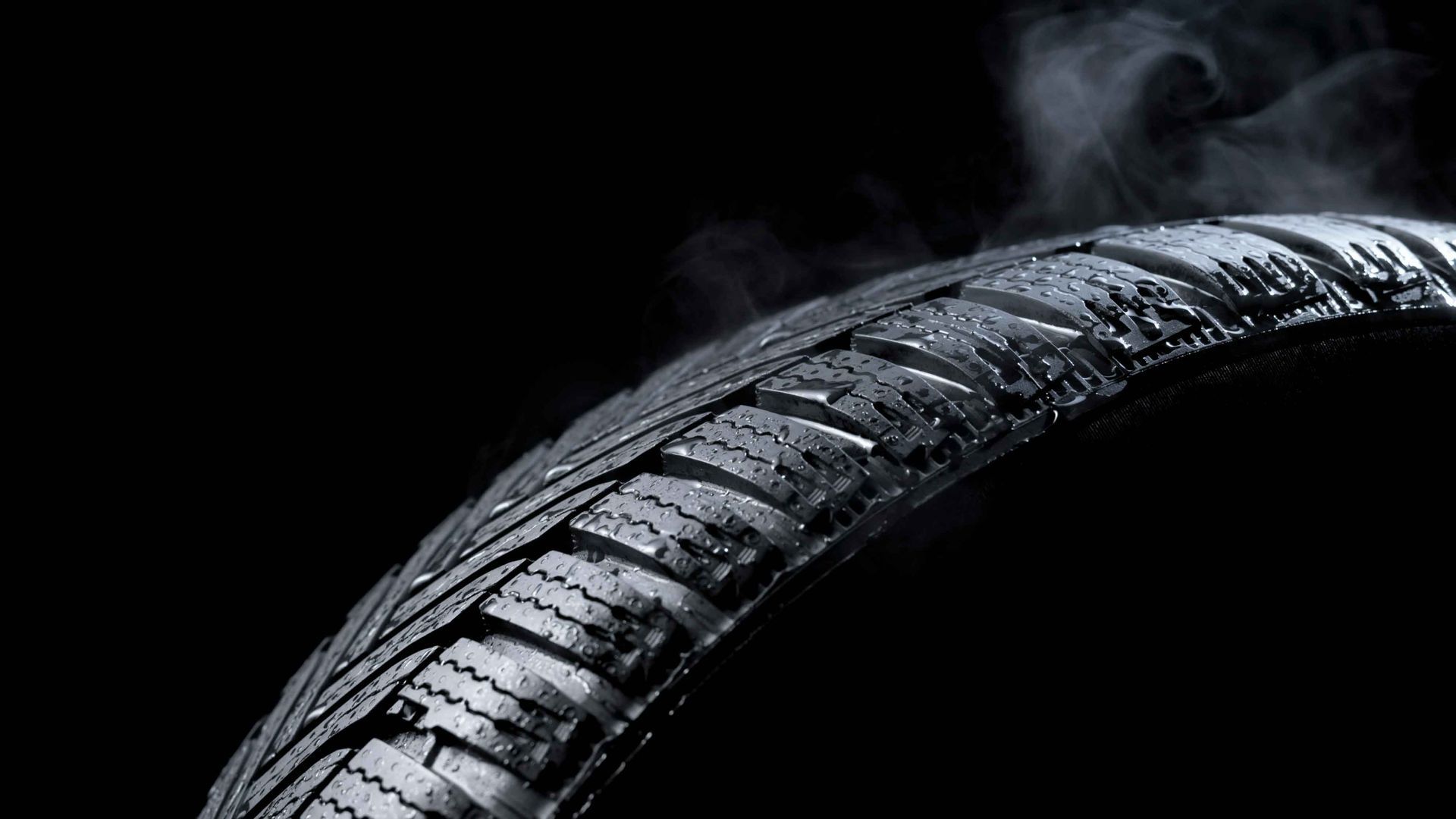 A close up of a tire with smoke coming out of it.