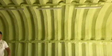 a man is standing in a room with a green ceiling .