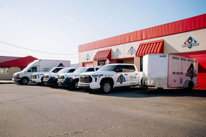 Food delivery vans parked outside a building with red awnings on a sunny day