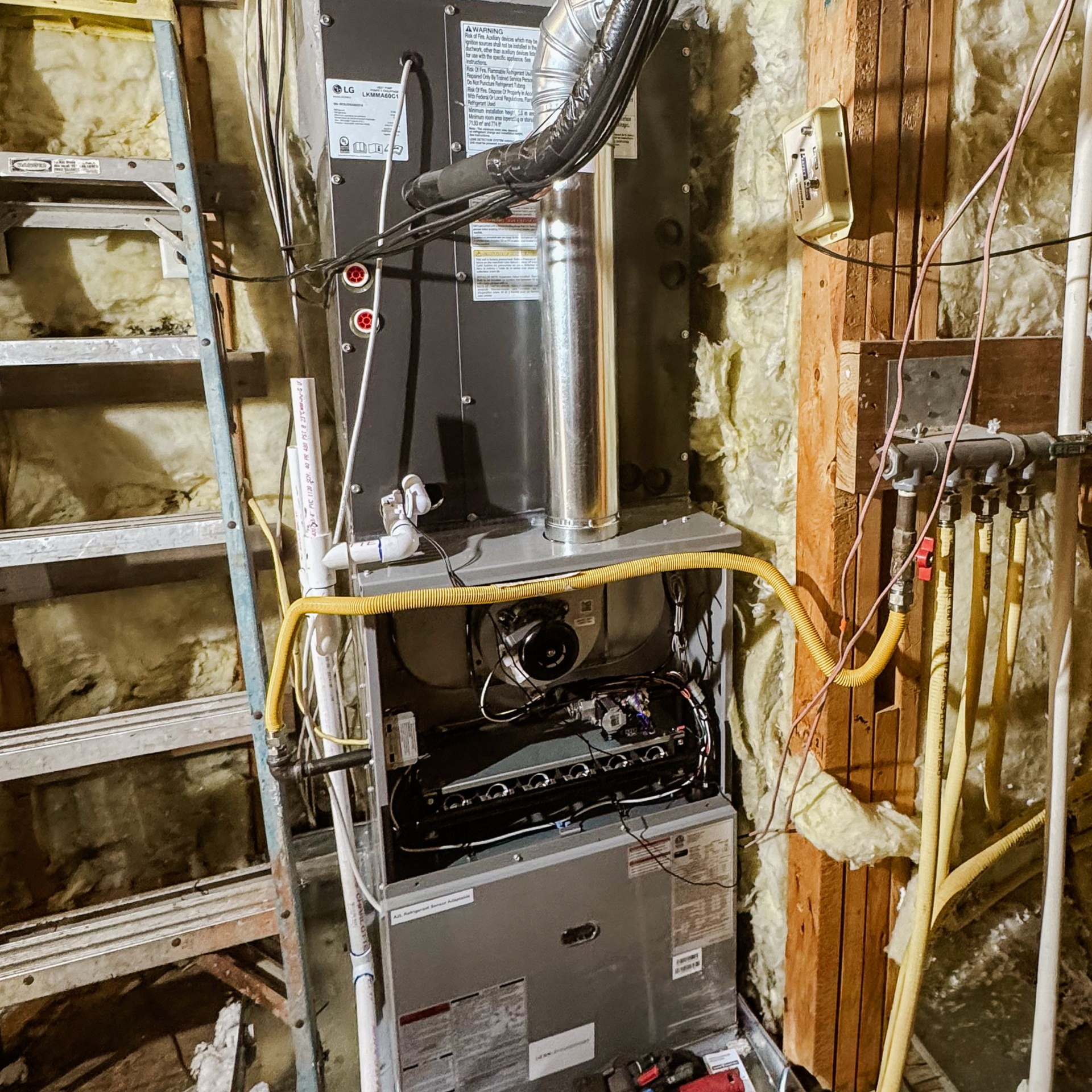 Installed furnace with exposed ductwork in an unfinished basement utility area