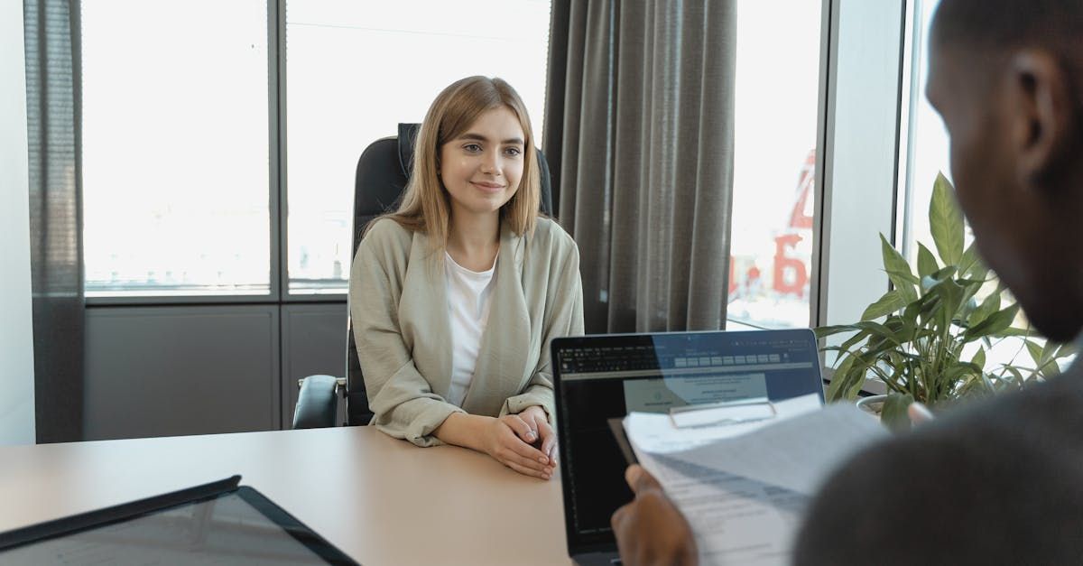 A woman is sitting at a table talking to a man.