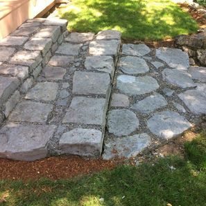 Stone steps leading through a grassy yard.