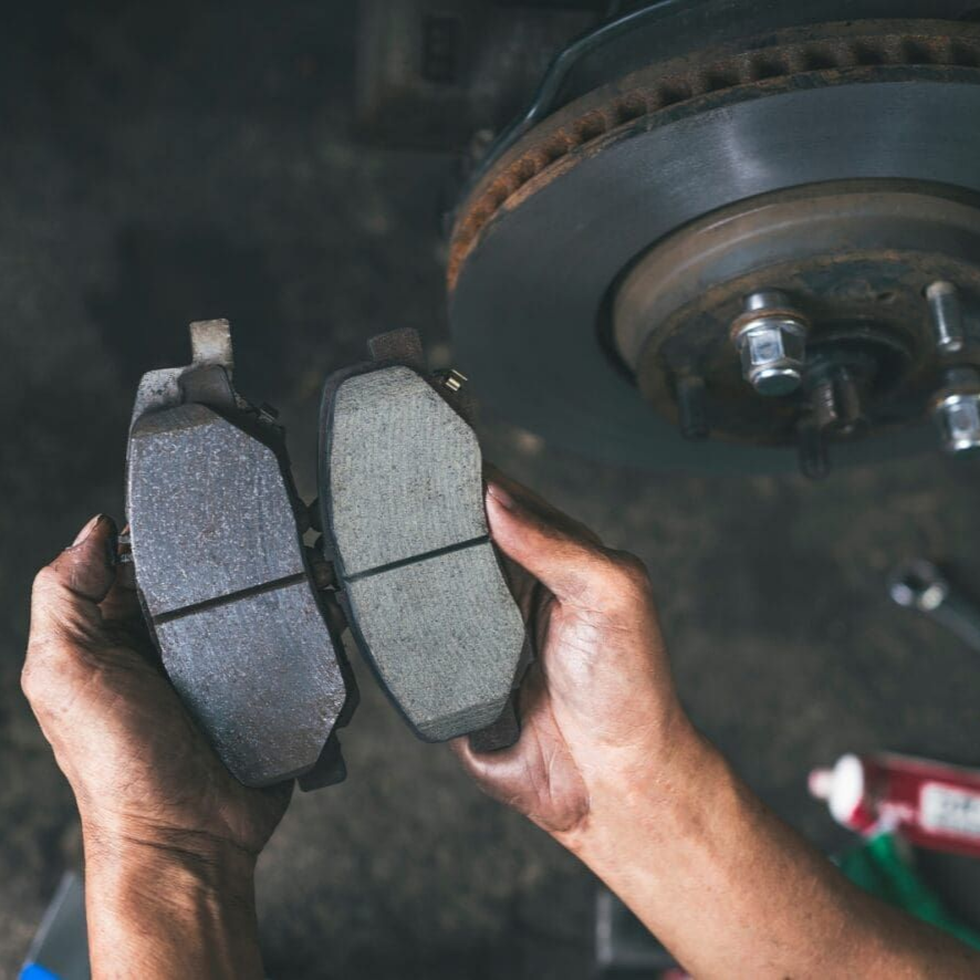 Hands Holding a Used Brake Pad Next to a New One — Alice Springs Auto Parts in Ciccone, NT