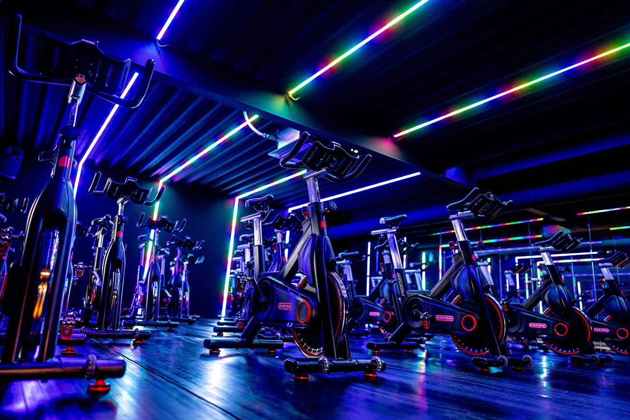 Een groep mensen fietst op een hometrainer in een sportschool.