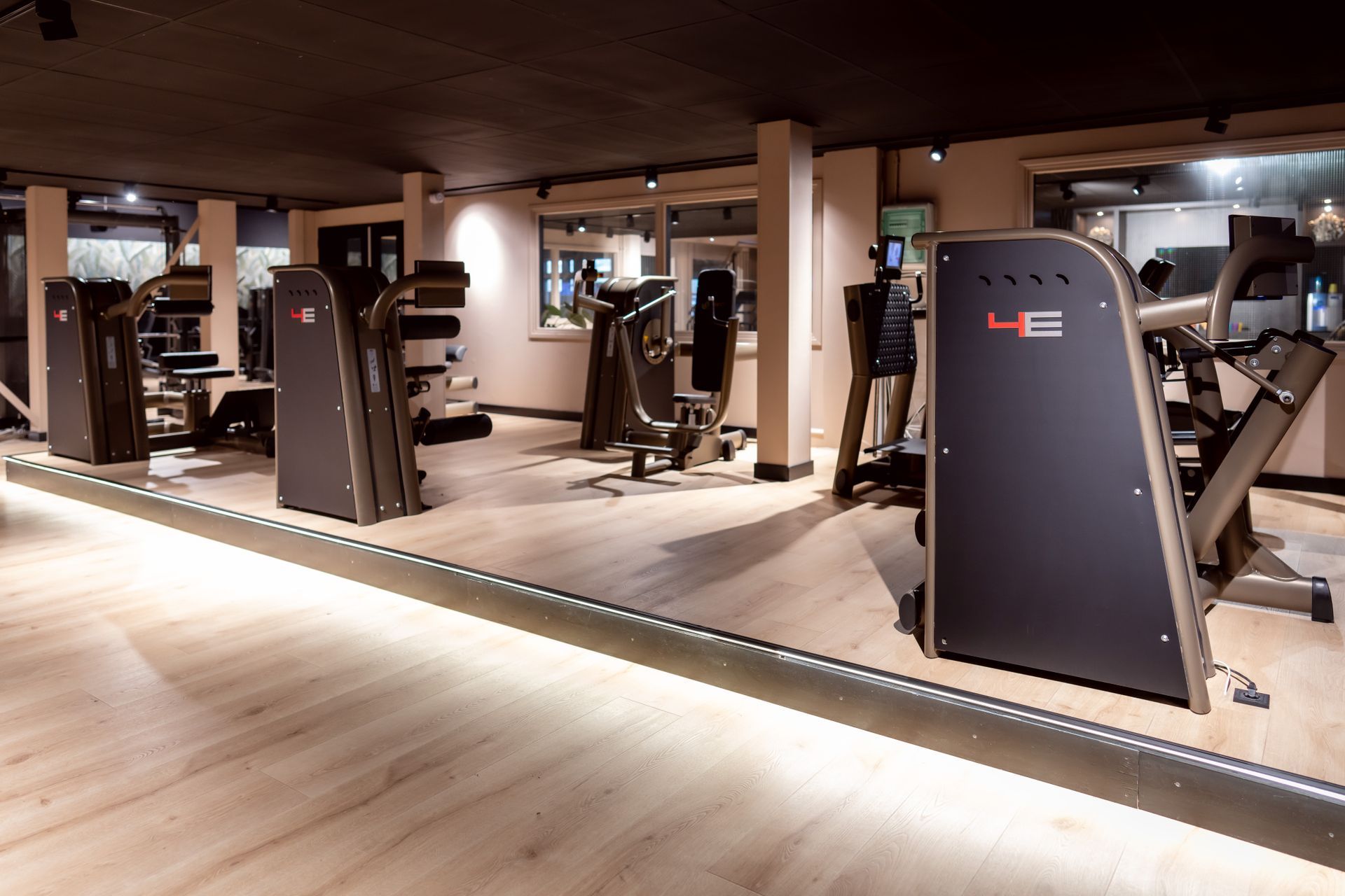 Een sportschool met veel fitnessapparatuur en een spiegel