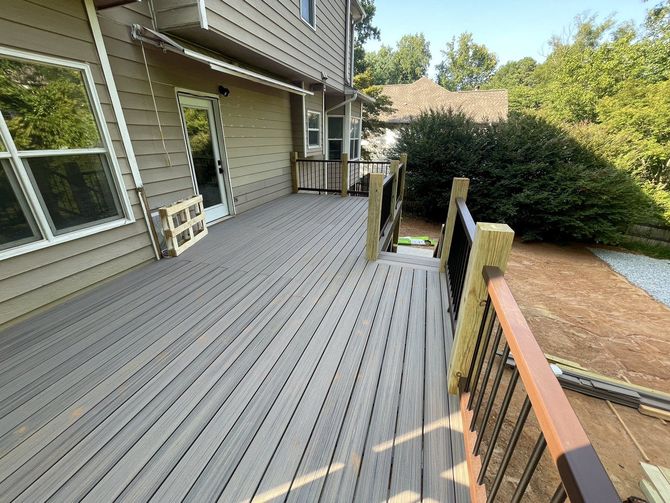 Finished composite deck with wood railing and black balusters in Lawrenceville, Georgia