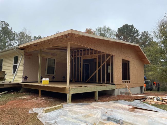 Covered porch under construction with timber posts and roof framing