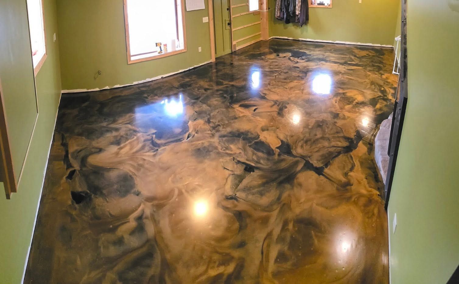 Glossy marbled epoxy floor in an empty room with green walls and bright window reflections