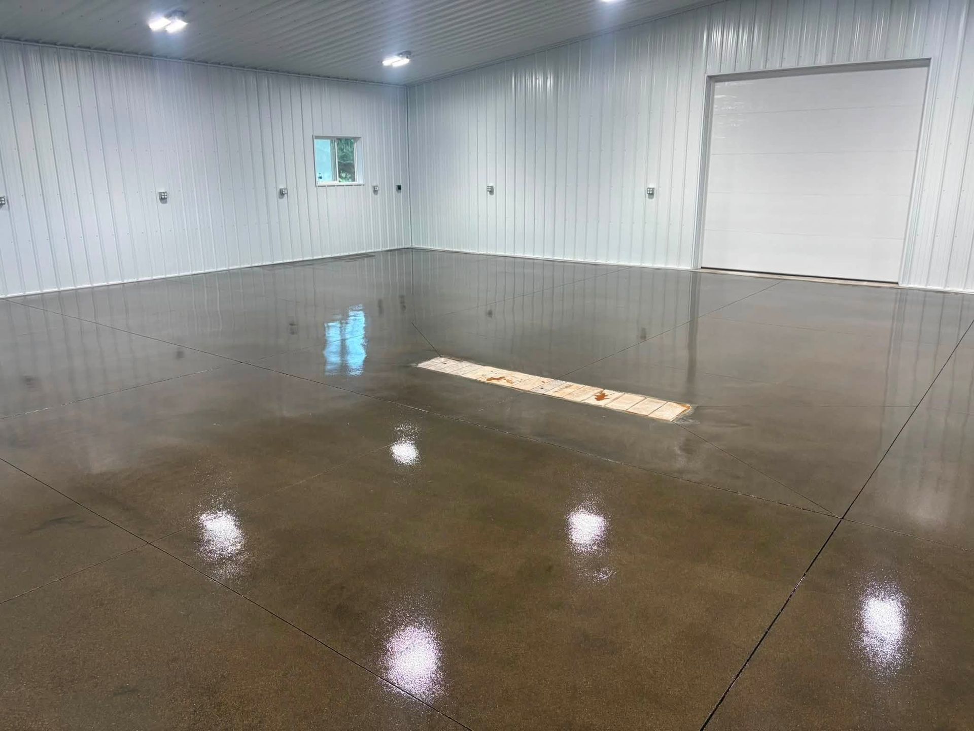 Empty industrial room with white walls and a glossy concrete floor