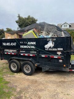 Black trailer filled with junk, branded