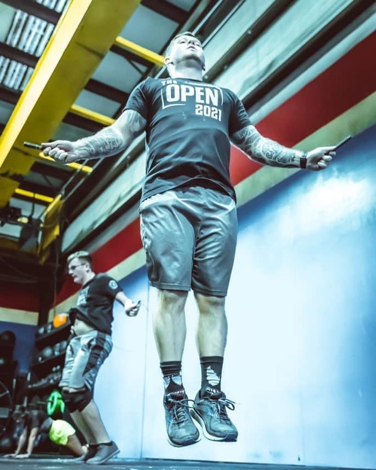 A man in an open 2021 shirt jumps a jump rope