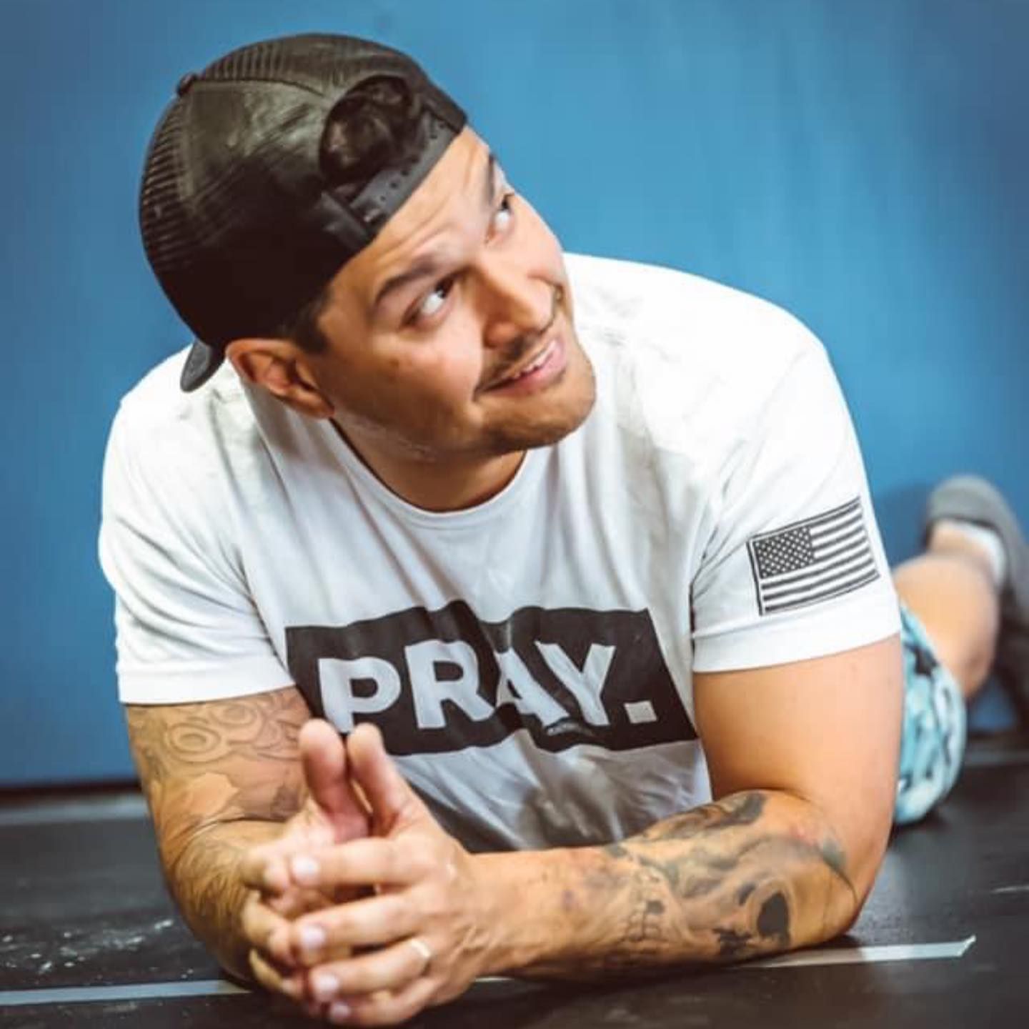 A man wearing a white shirt that says pray