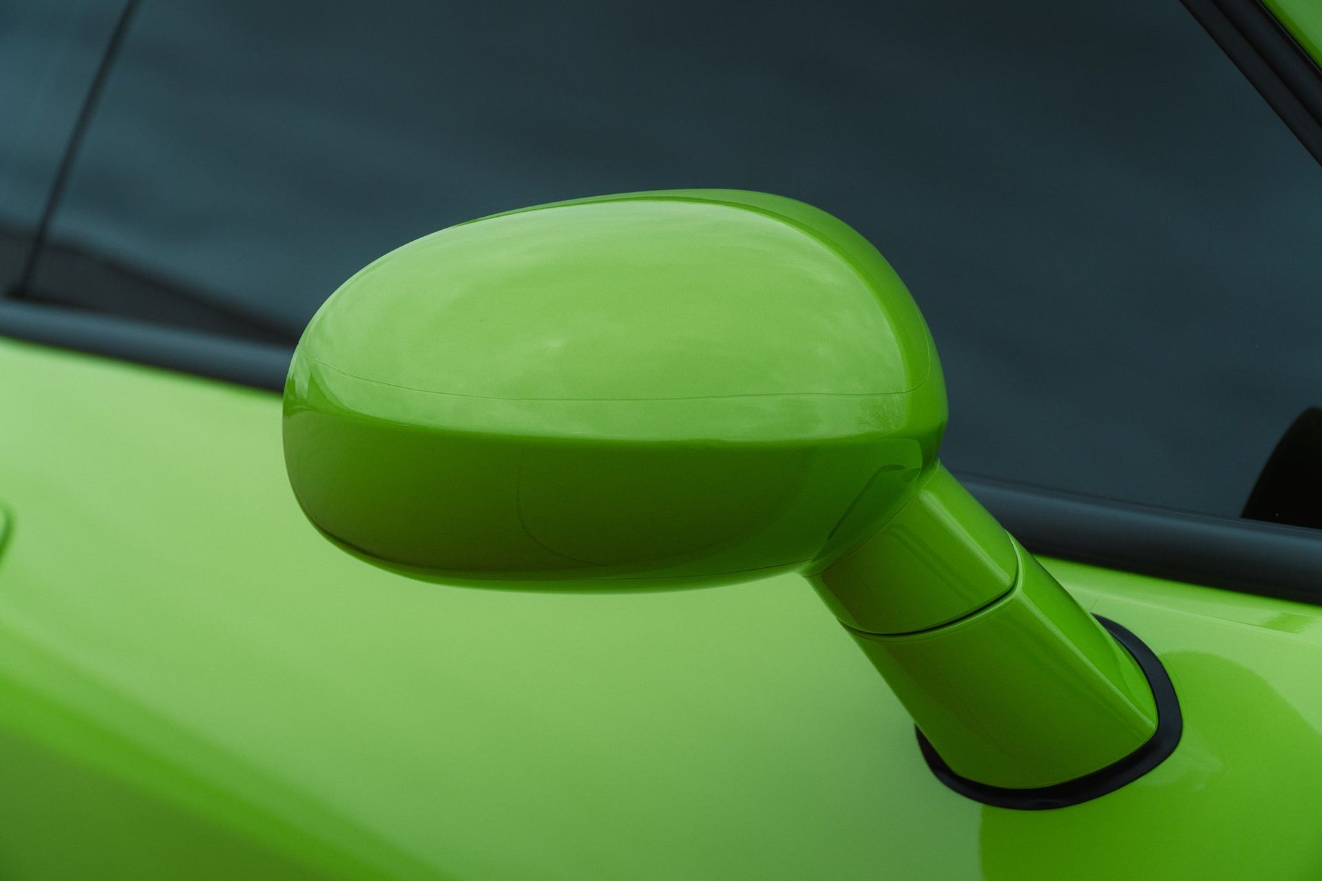 Bright green car side mirror on a matching green vehicle door