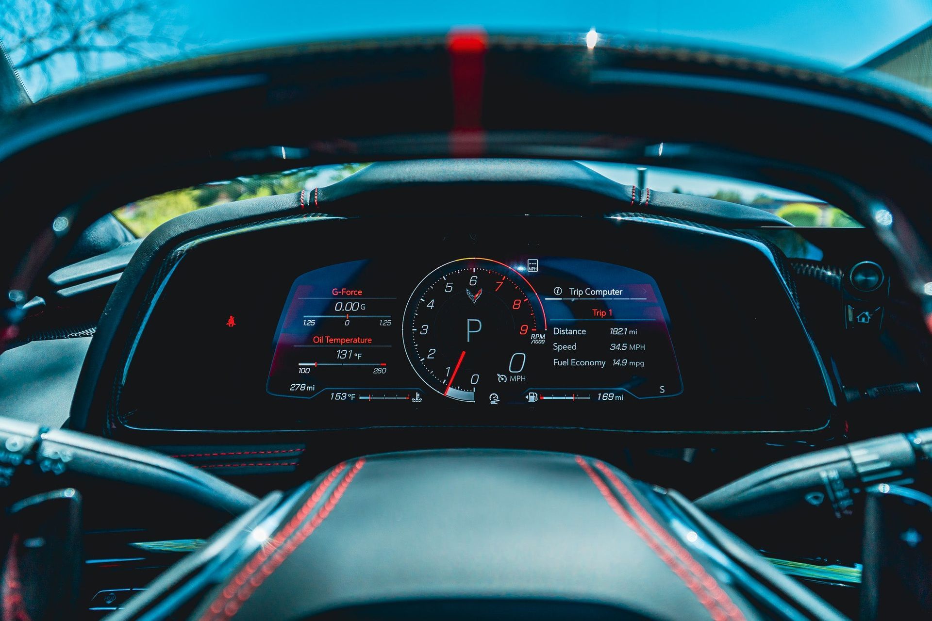 Driver’s view of a futuristic car dashboard with a digital instrument cluster and blue-red lighting
