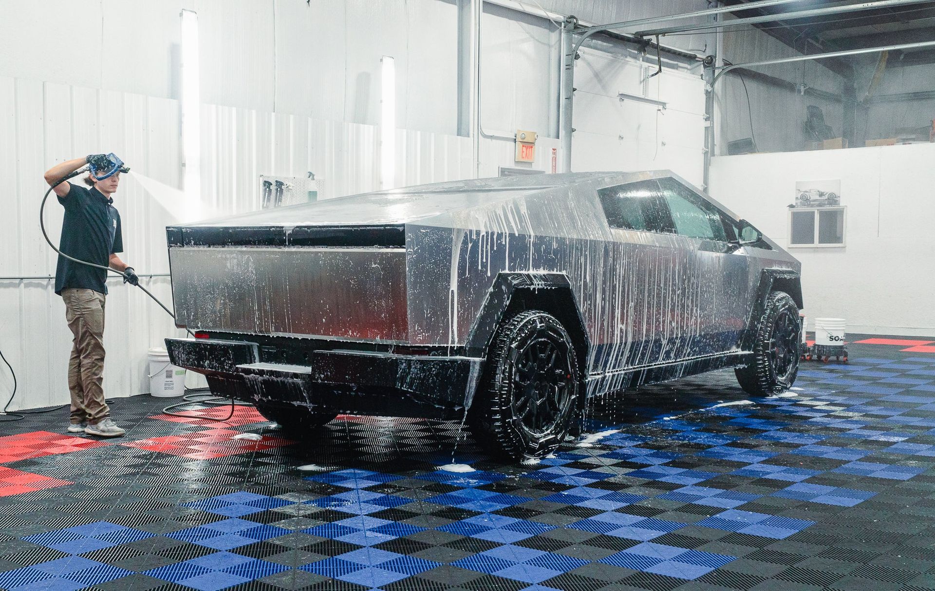 Pickup truck being pressure-washed in an indoor car wash bay