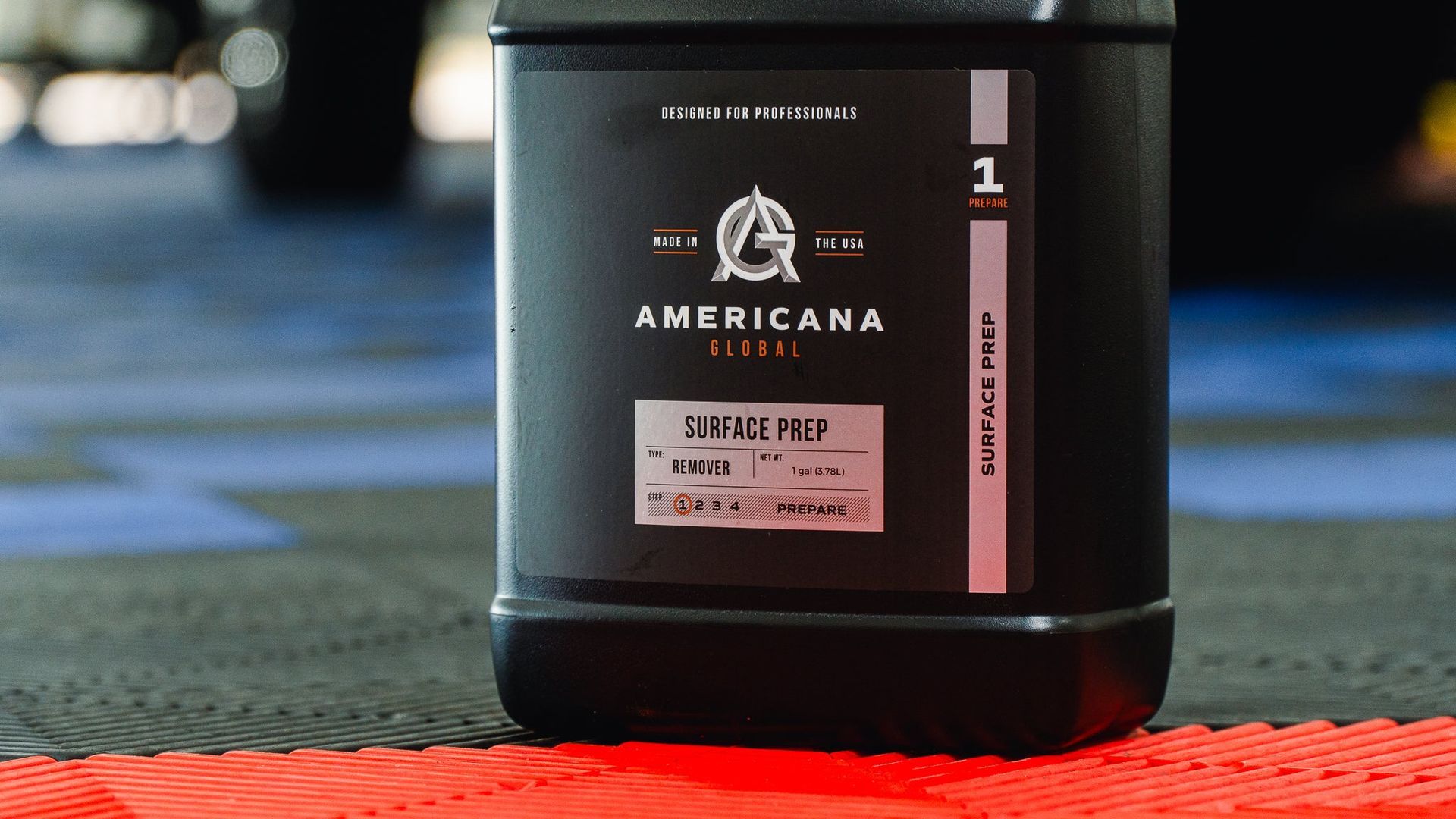 Black Americano coffee jar with pink label on a table, blurred background