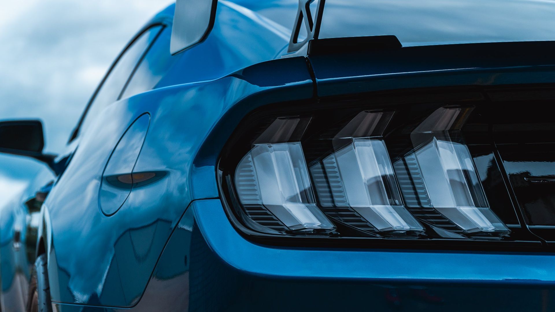 Close-up of a blue sports car rear taillight with three LED bars