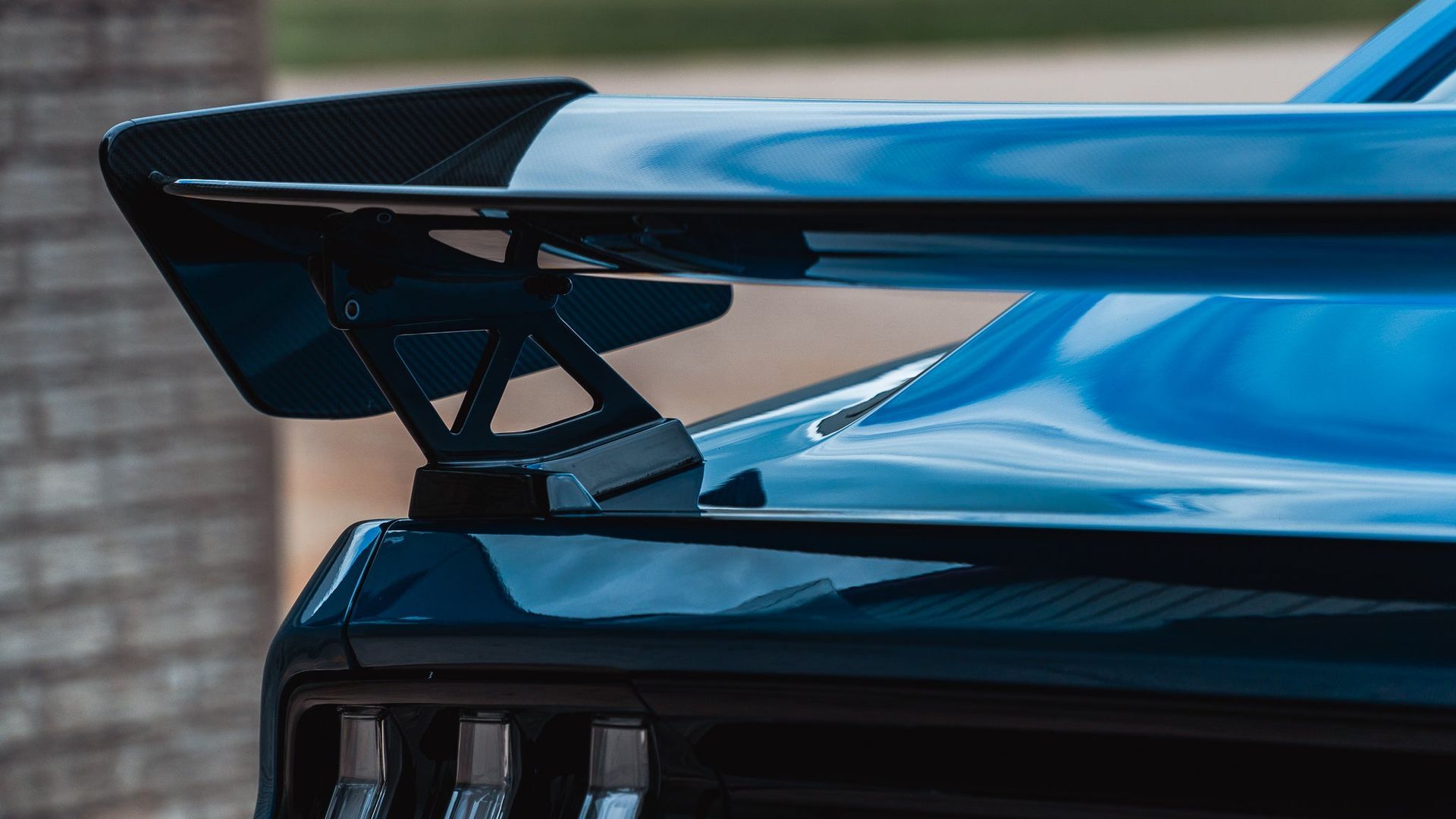 Rear spoiler on a blue sports car, close-up view