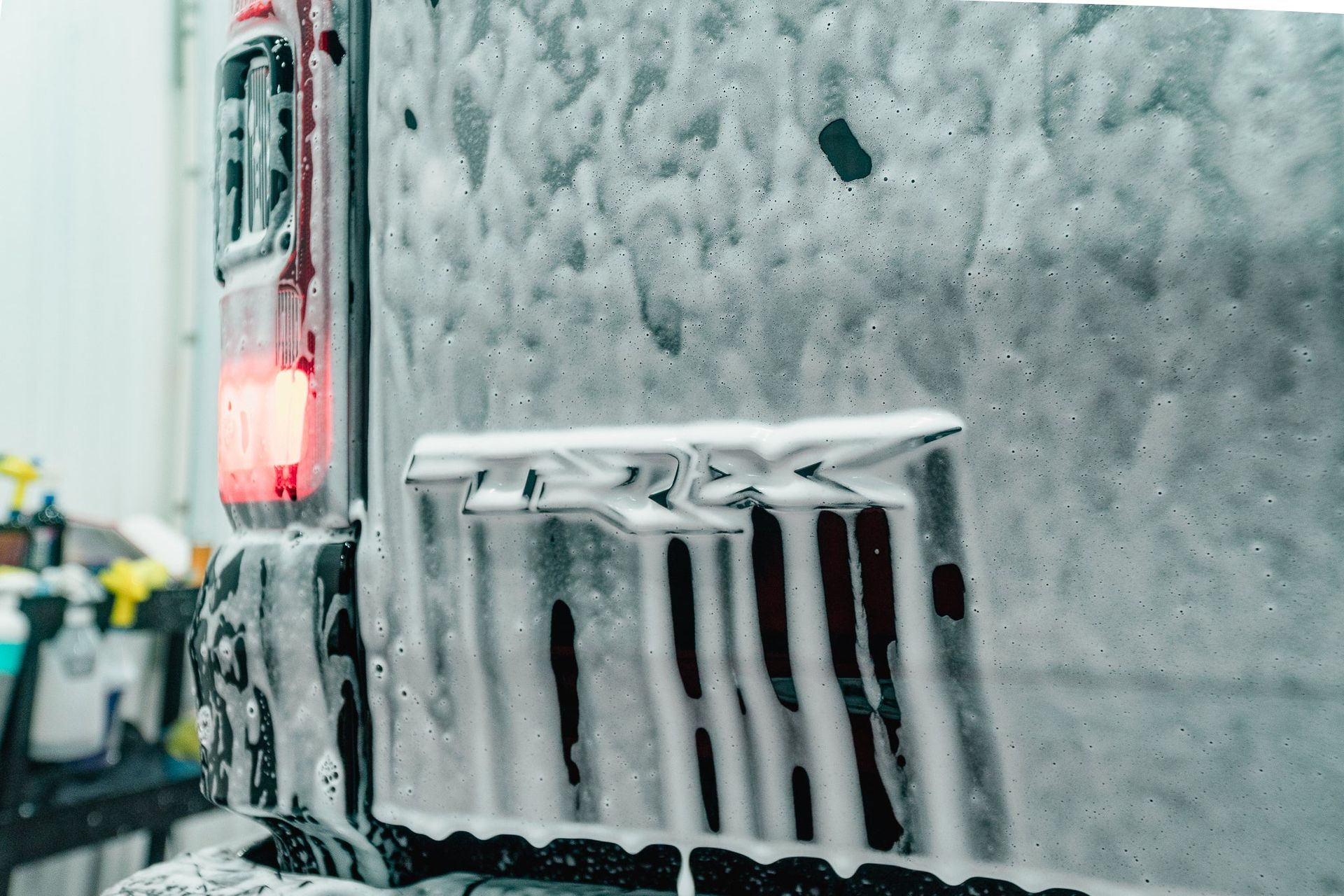 Icy truck rear covered in snow and frost, with a red taillight glowing on a snowy street