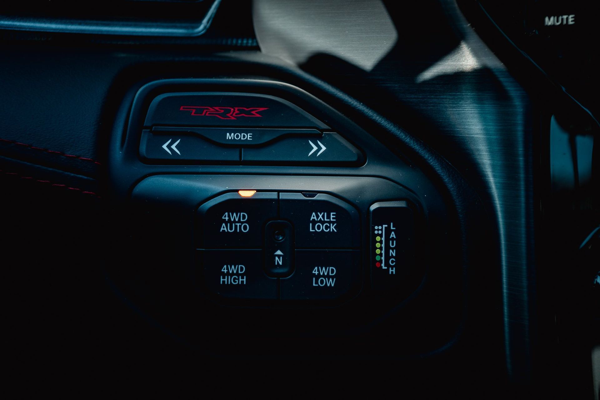 Close-up of a car climate control panel with illuminated buttons and blue-accented display icons