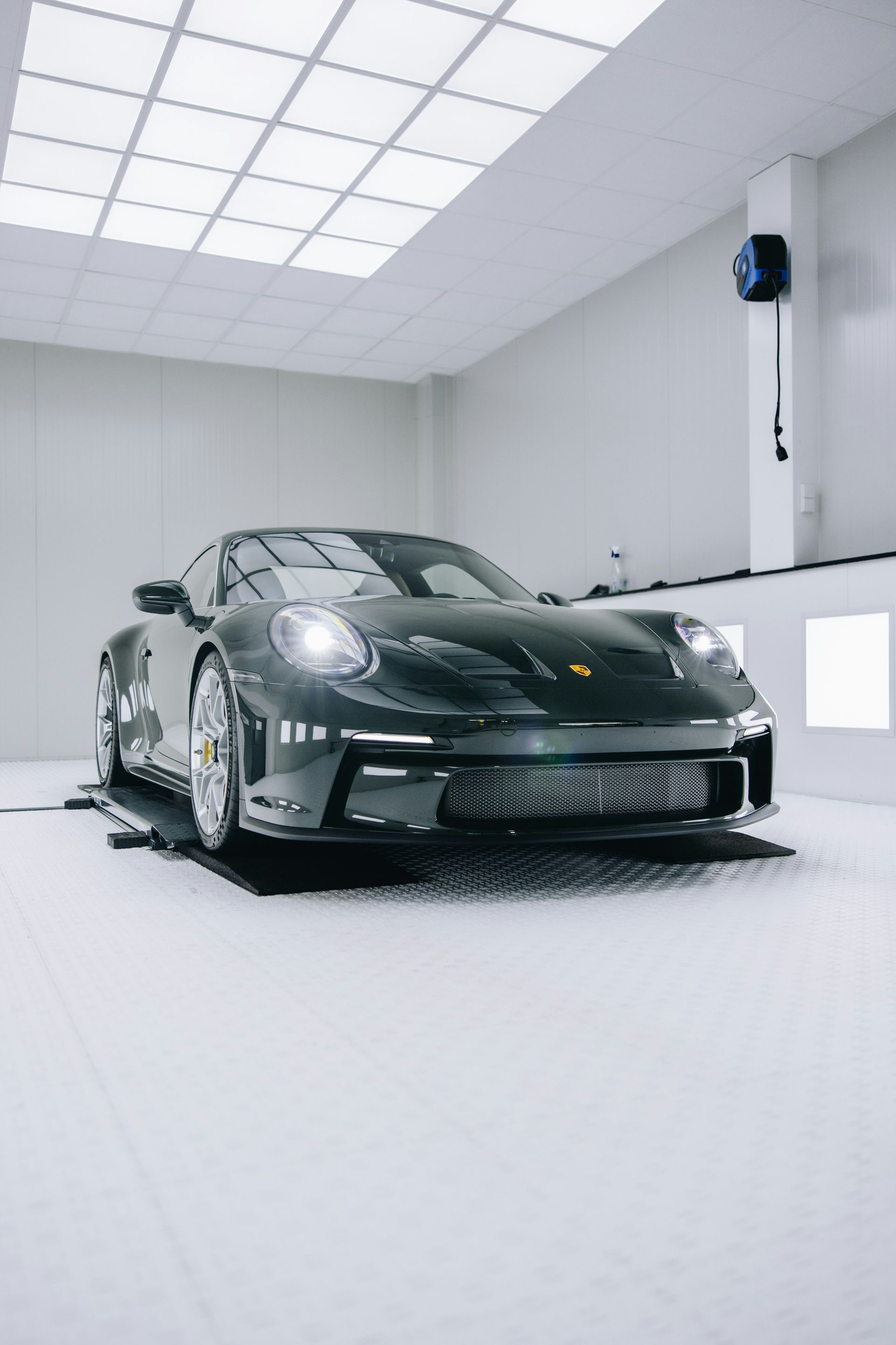 Black sports car in a white studio on a test platform