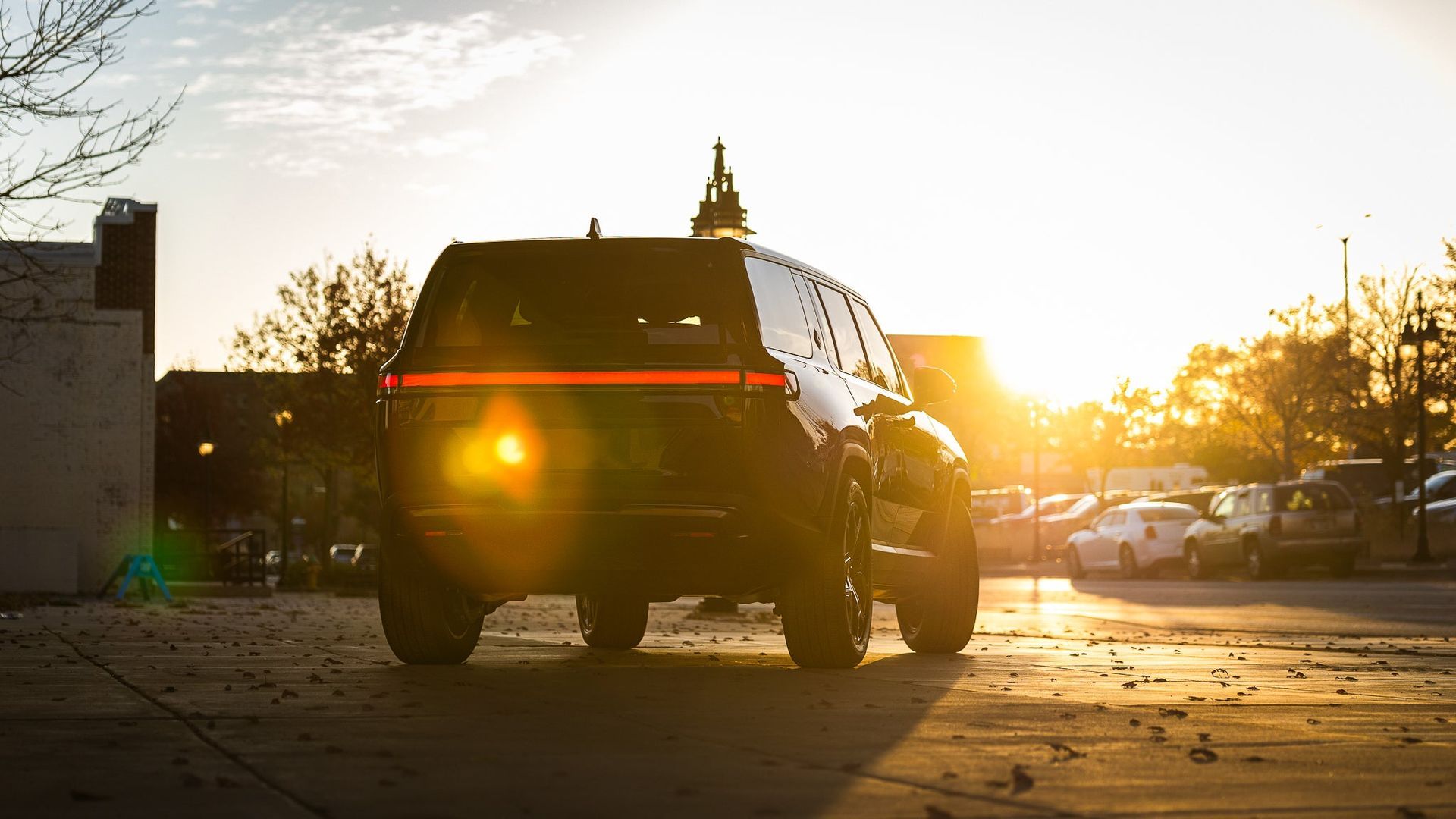 SUV parked at sunset with bright sun glare in a driveway