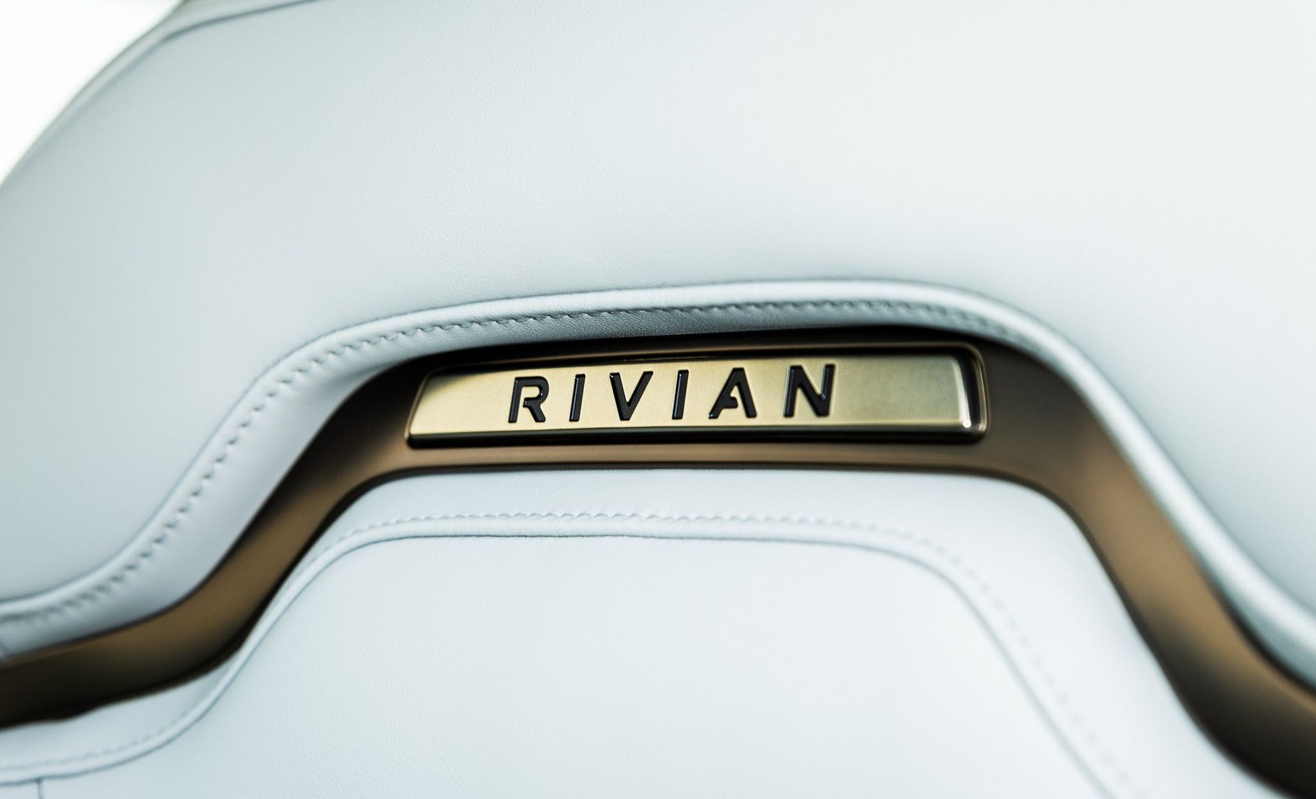RIVIAN logo on a beige and silver car interior panel