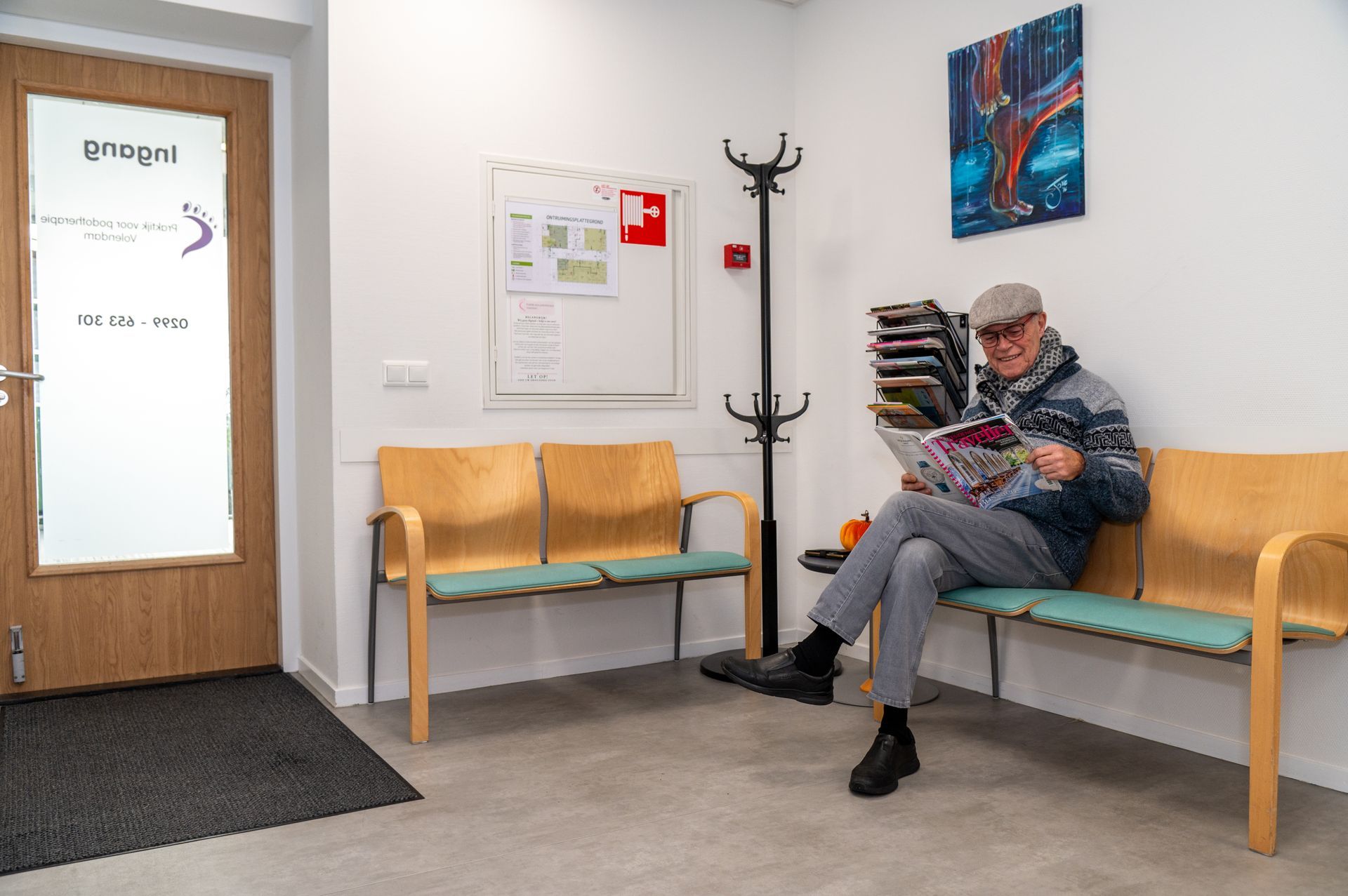 Wachtkamer van Praktijk voor Podotherapie Volendam met patiënt die leest terwijl hij wacht op de afspraak.