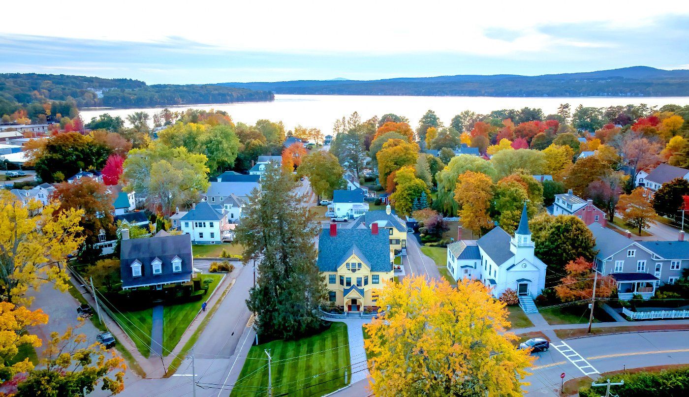 An aerial view of a small town with a lake in the background.